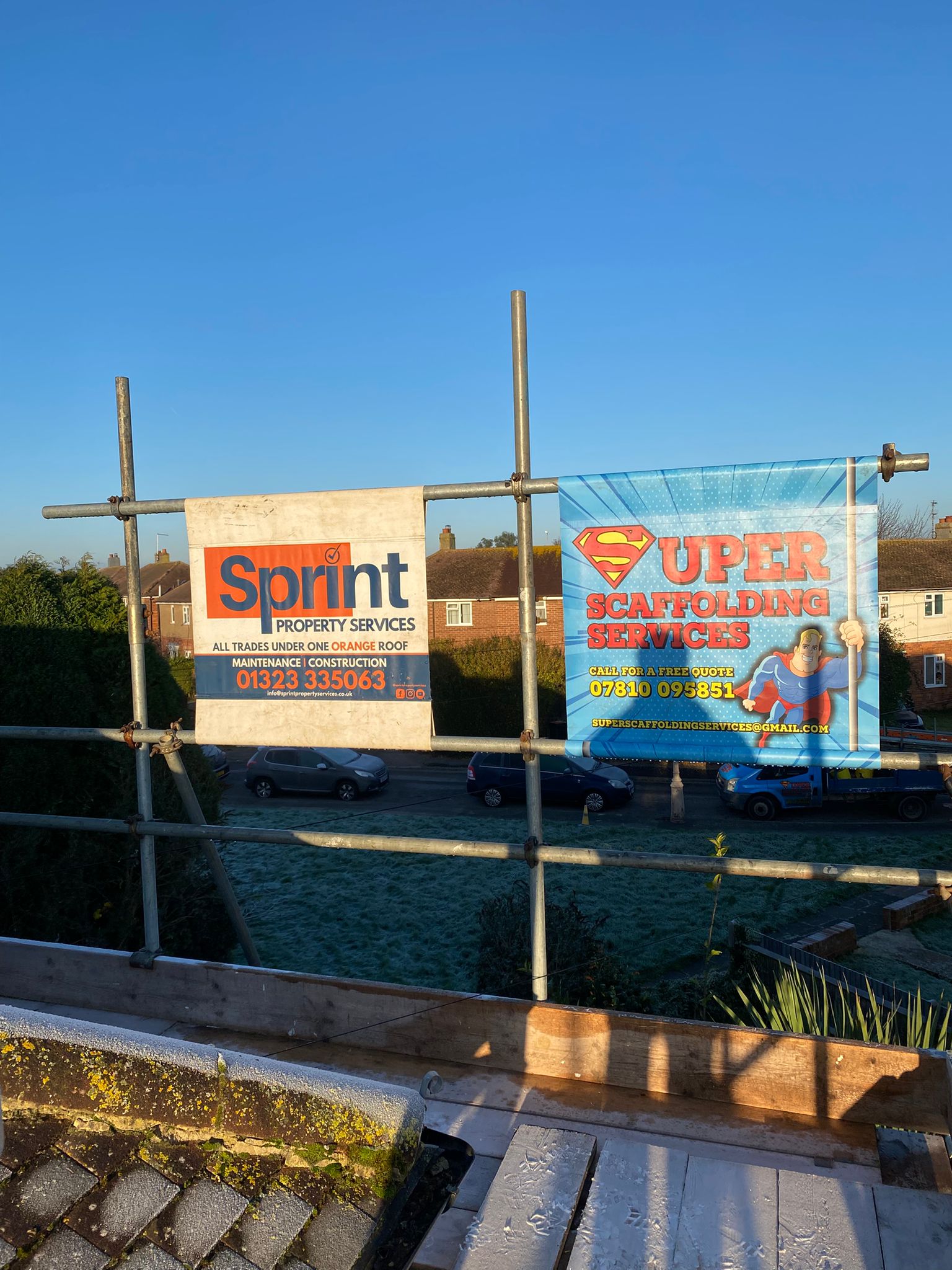 The Super Scaffolding Services banner tied to a scaffold, with the phone number and email